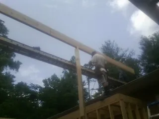 Carpenter setting a ridge beam over a new addition frame — Ice Dam Removal by Roofing Brothers in Josephine