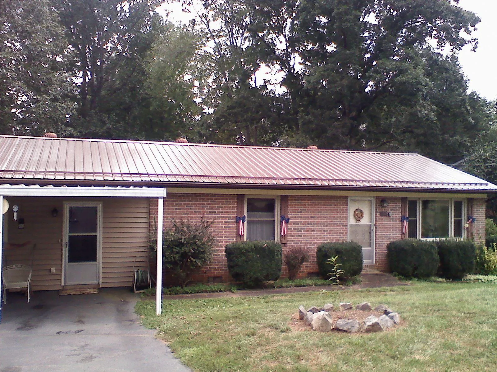 Bronze metal roof and carport on a brick ranch home — Roof Repair work by our crew in Josephine